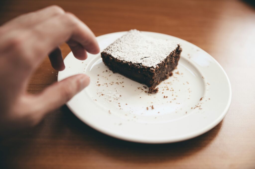 person reaching for last brownie on a plate