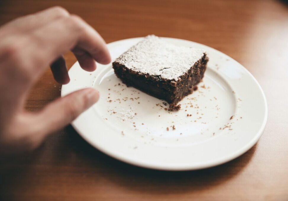 person reaching for last brownie on a plate