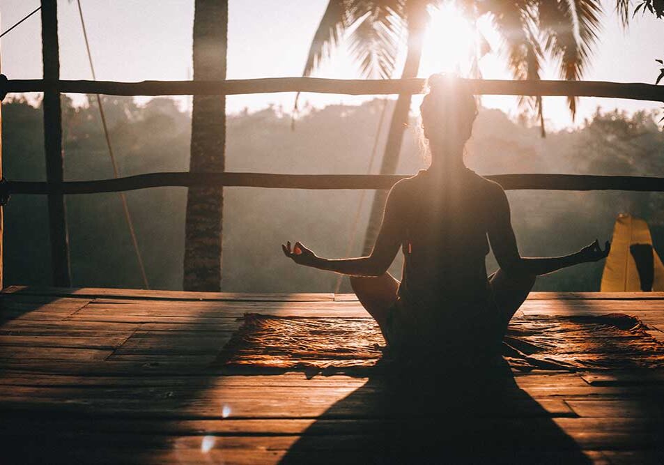 A women doing yoga at sun rise