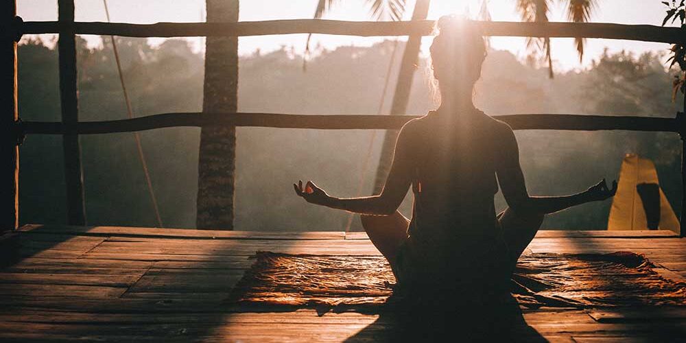 A women doing yoga at sun rise